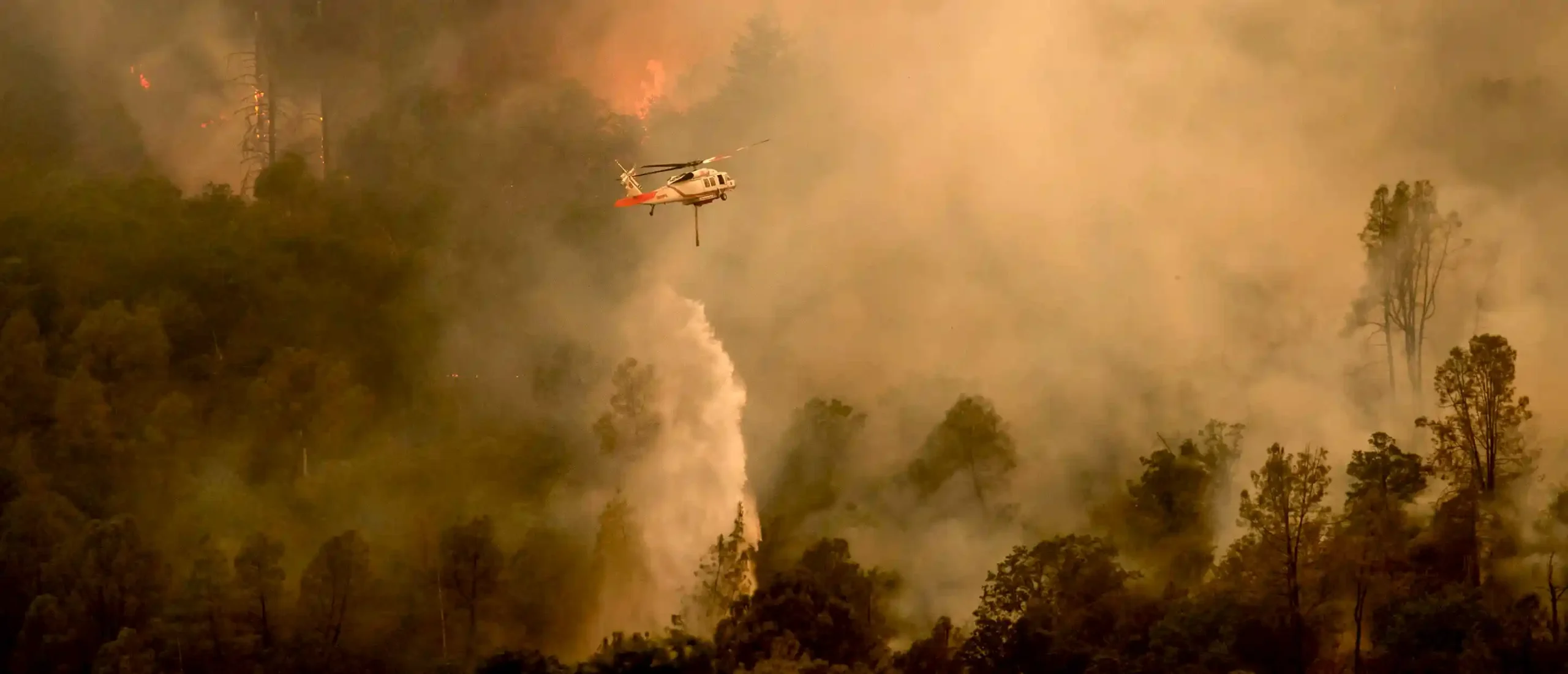 Um helicóptero combatendo incêndios florestais na área de Aetna Springs, no condado de Napa, Califórnia
